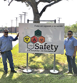 UTRGV employees next to a UTRGV EHSRM banner outside.