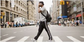 Pedestrian walking while using a cell phone.