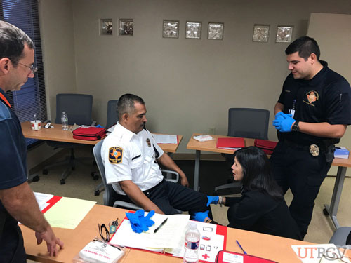 After asking SAMPLE questions, a head-to-toe check is performed by University Police employee Dora Maldonado as Officer Jose Gonzalez plays the role of an injured or ill person.