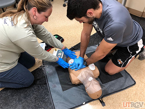 Teammate is placing AED pad on adult chest without interrupting her partner’s chest compressions, December 14, 2018.