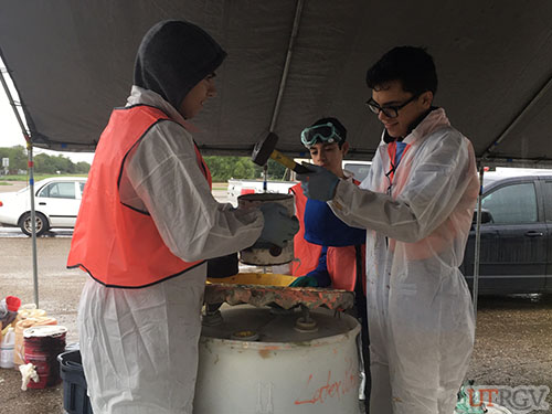 Volunteers handle household waste while wearing personal protective equipment (PPE), December 1, 2018.