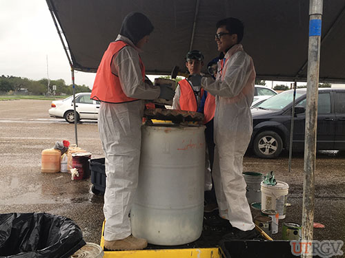 Volunteers handle household waste while wearing personal protective equipment (PPE), December 1, 2018.