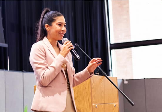 Presentation Speaker stands and delivers speech into microphone