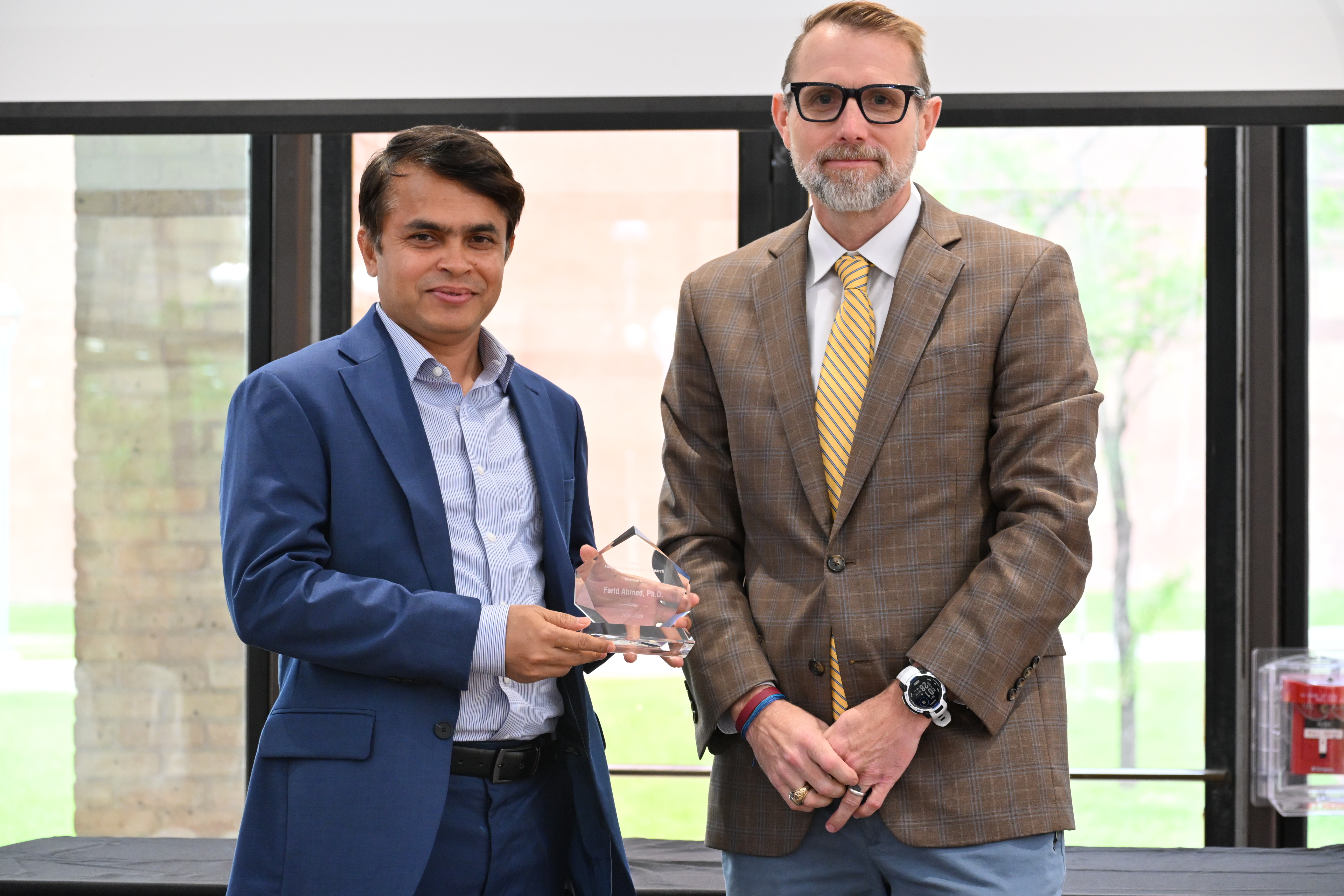 dr farid ahmed posing for a picture with dr dearth with his faculty impact award in research
