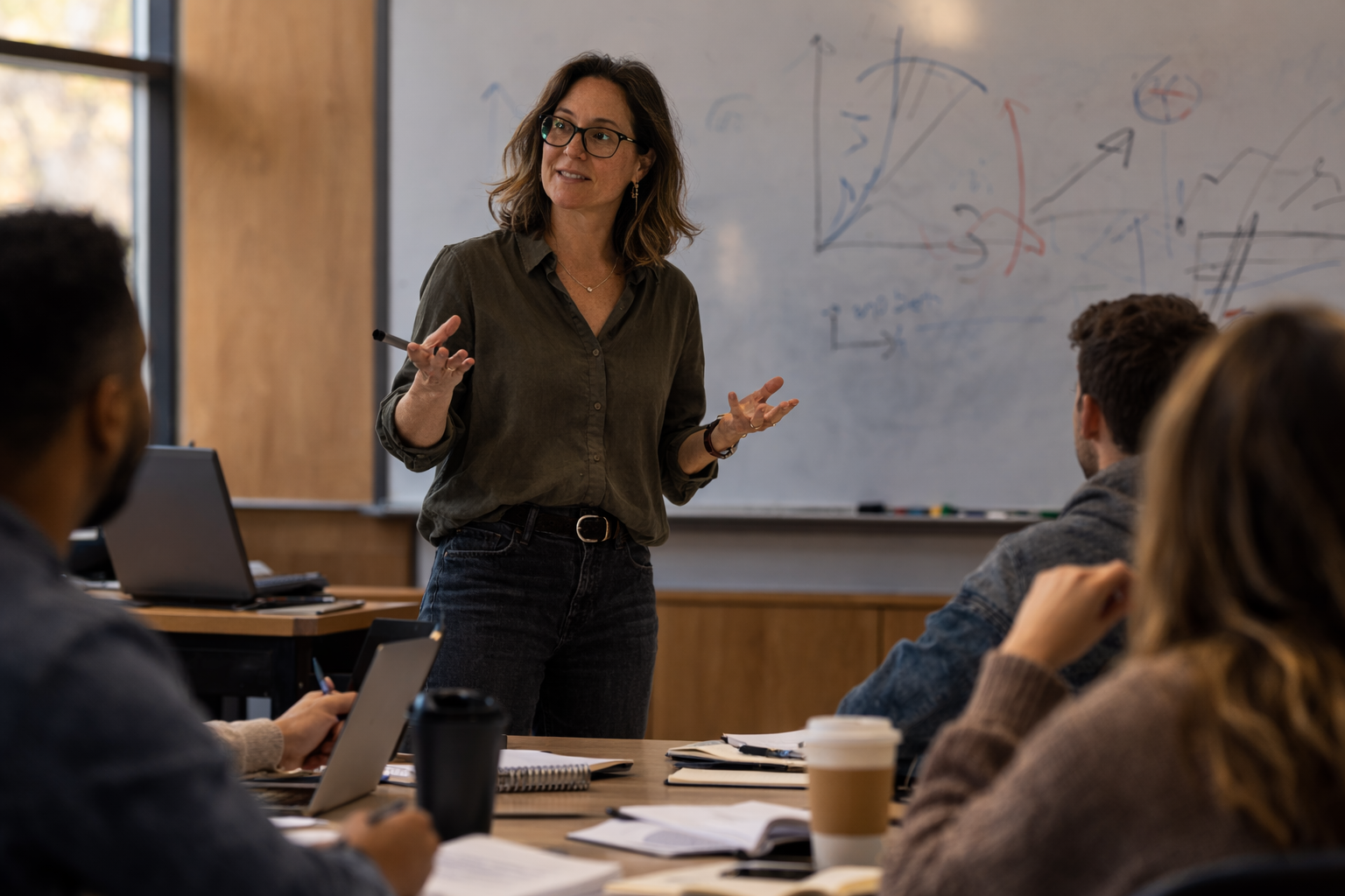 a teacher giving instruction in front of a whiteboard