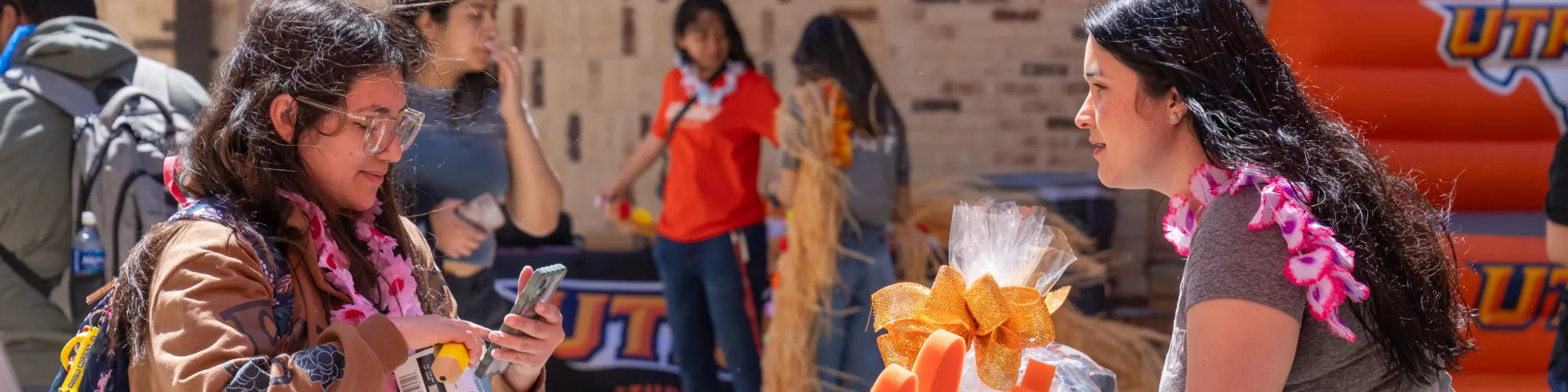 Tabling event with student talking to another student.