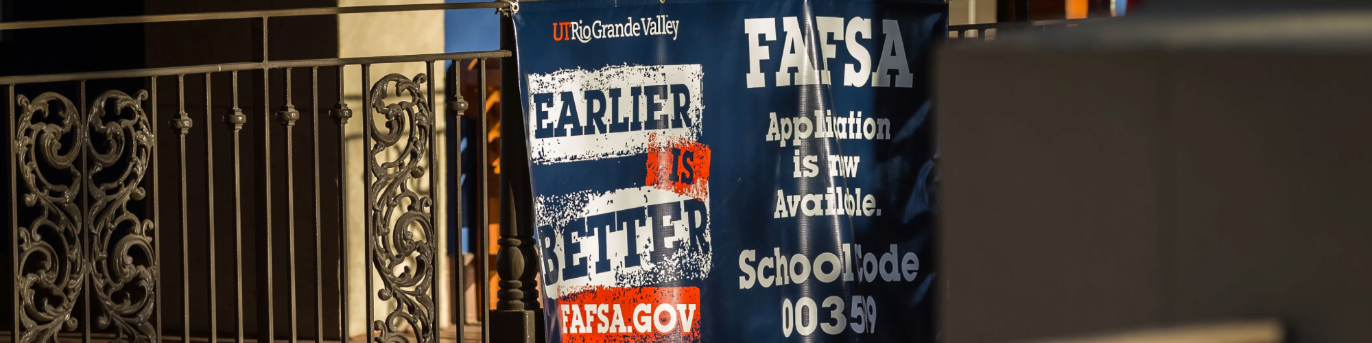 FAFSA banner on a fence on campus.