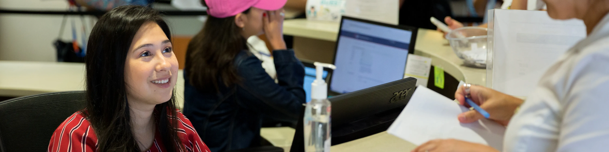 Work-Student sitting at a desk answering someone's question.