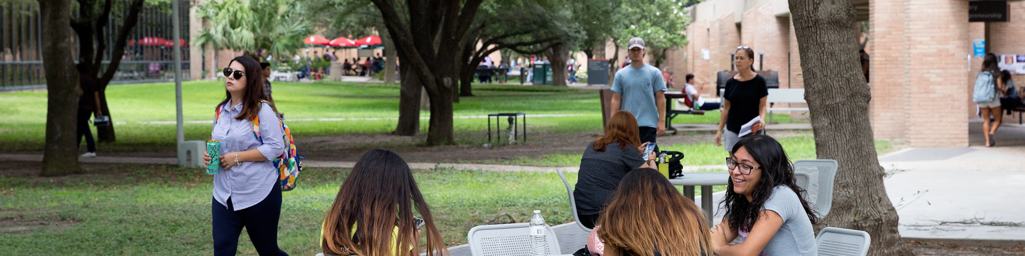 Students sitting at a table outside on campus.