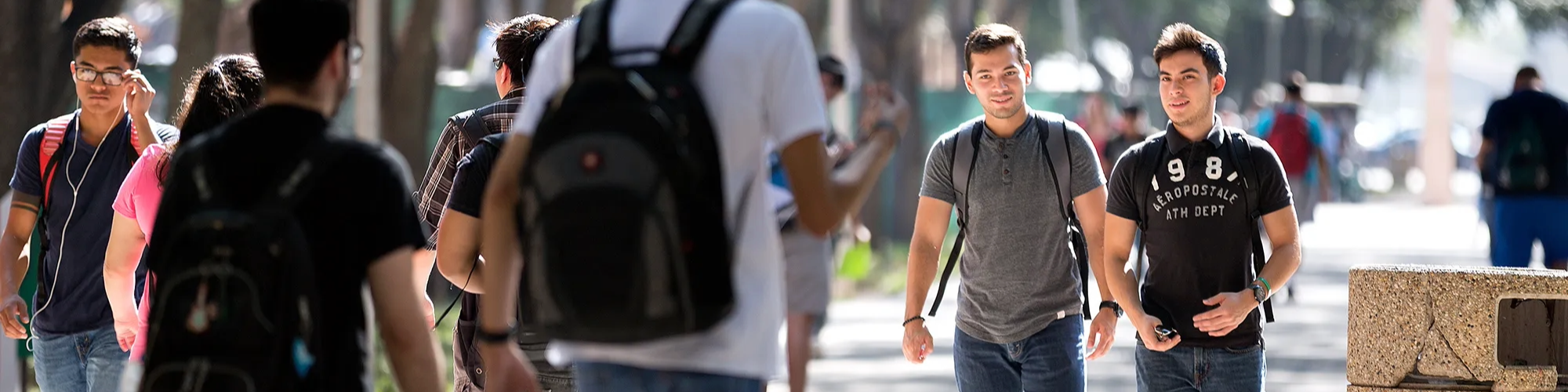 Large group of students walking on campus.
