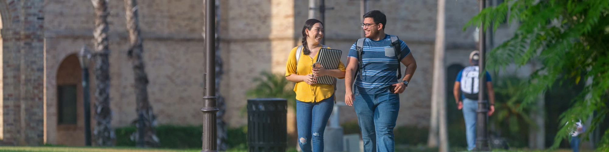Two students walking outside on campus and talking.
