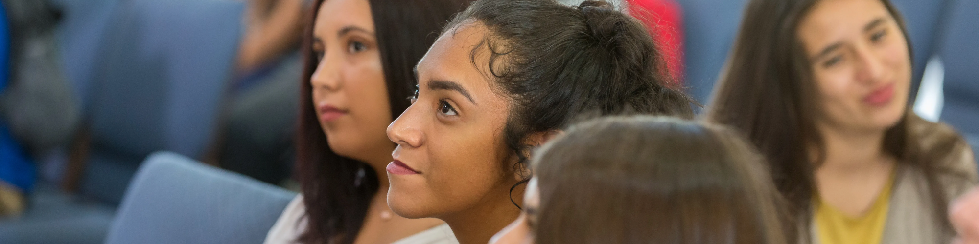 Three students sitting and listening to speaker.
