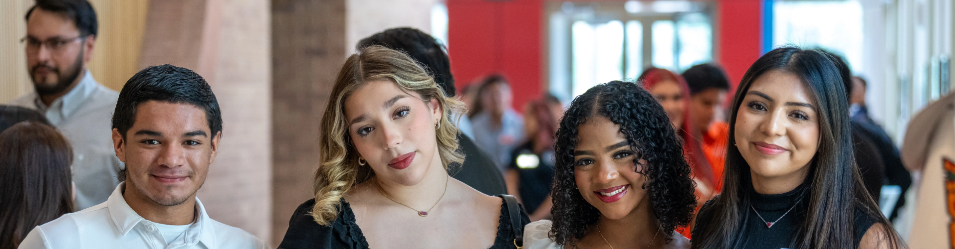 Students standing in a row smiling at the camera.