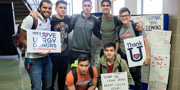 UTRGV mens soccer team holding thank you signs