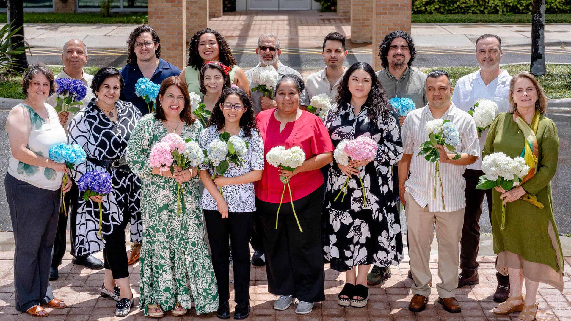 Memory and Aging Center team gathers outdoors holding flowers, celebrating collaboration and commitment to Alzheimer's research and community health.