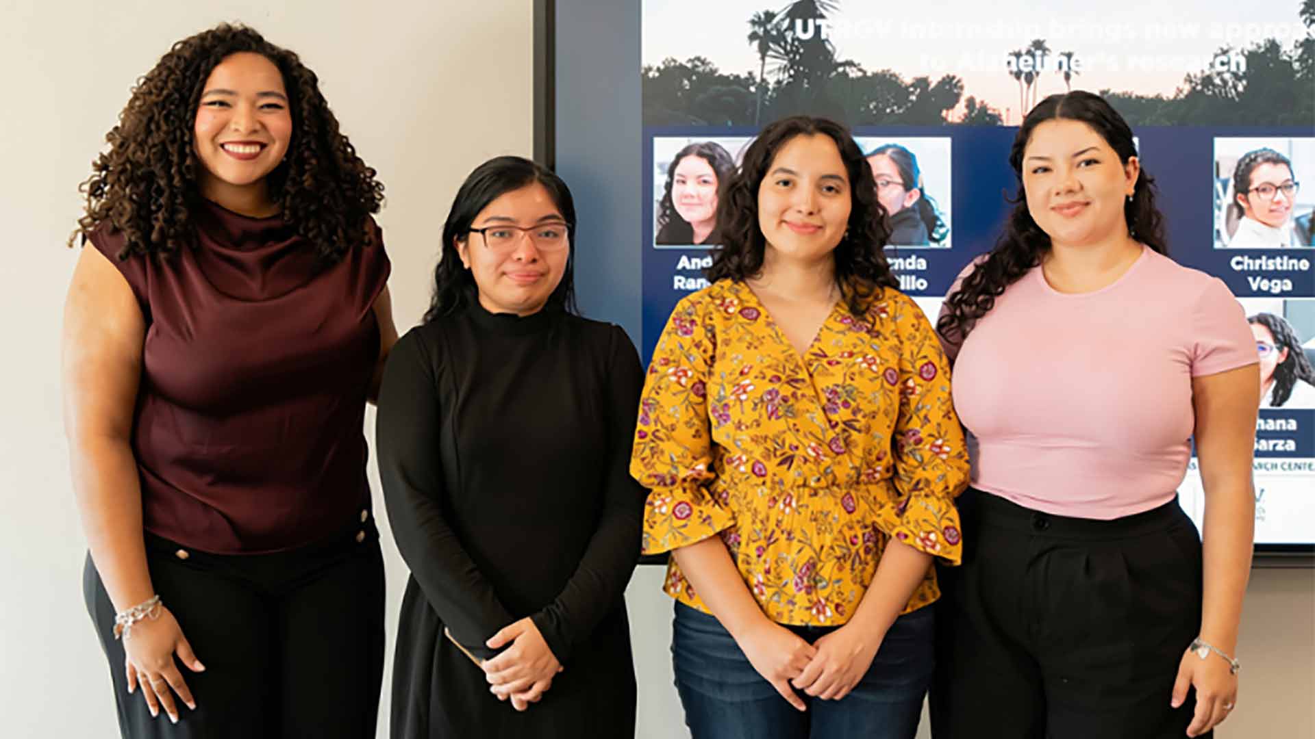 Four student researchers gather for a group portrait highlighting participation in a collaborative research program.