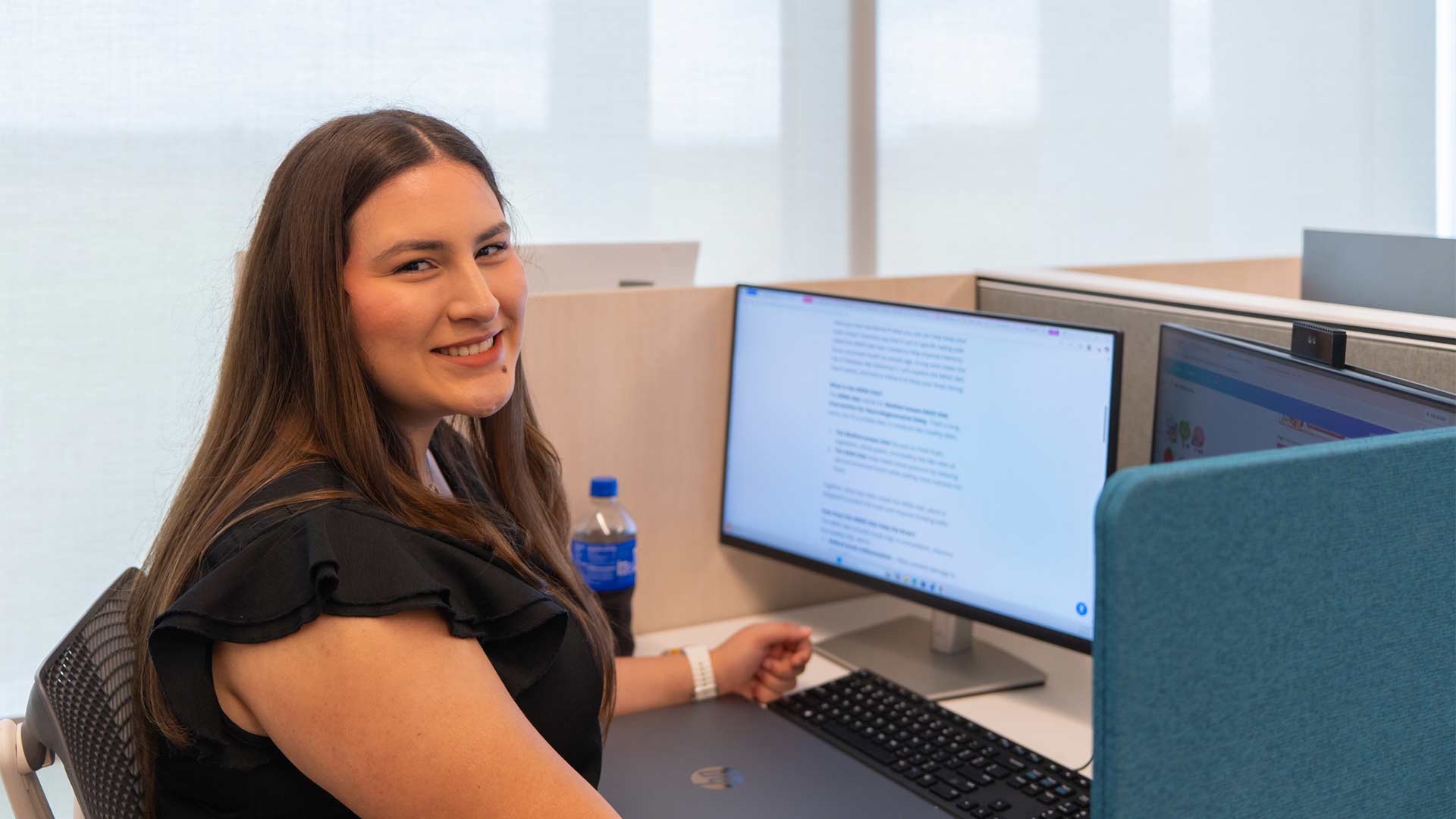 Student researcher works at a computer in a professional office, gaining hands-on experience through a research program.