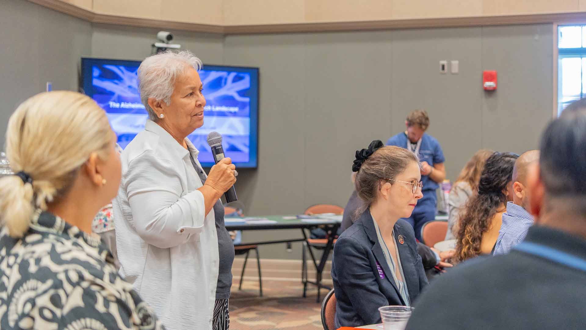 Community member shares insights during an Alzheimer's discussion, contributing lived experience to research and care planning.