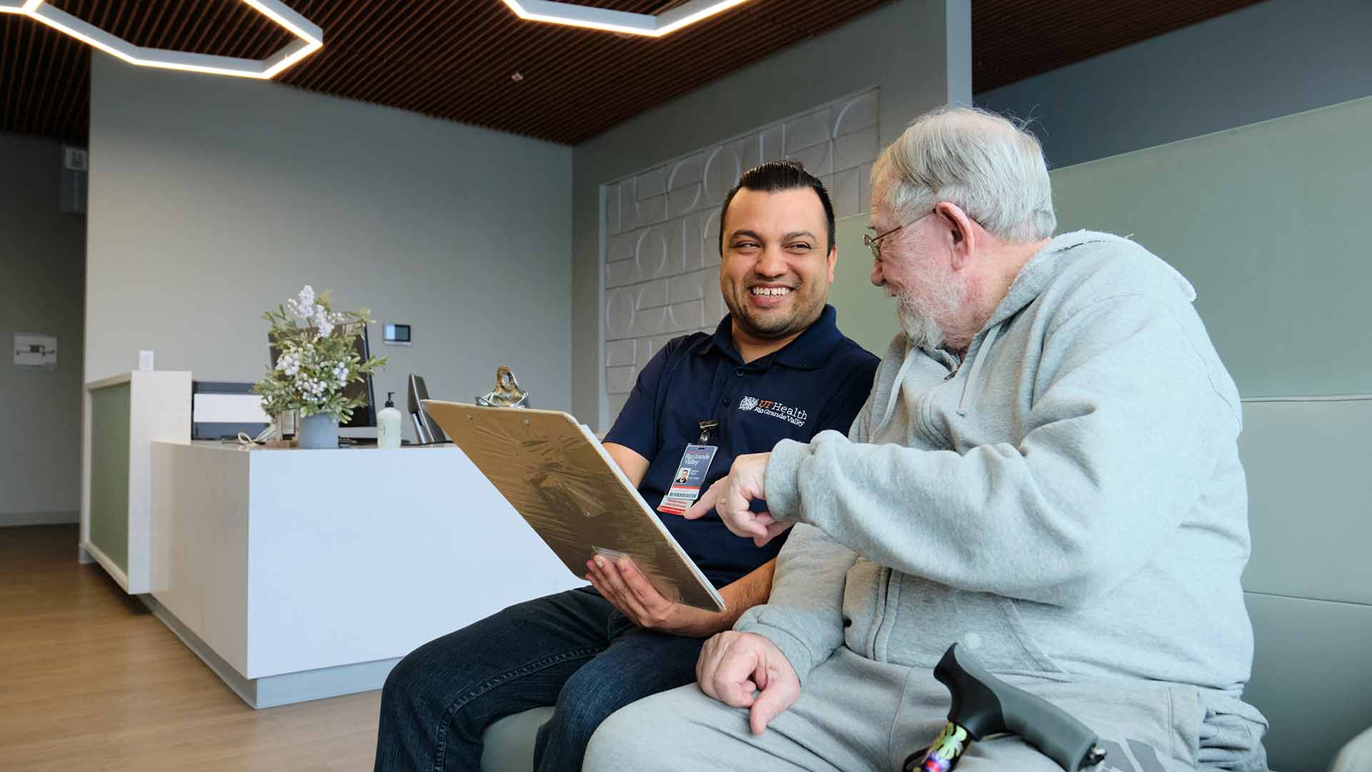 Healthcare staff reviews information with an older adult, supporting informed decisions and personalized care.