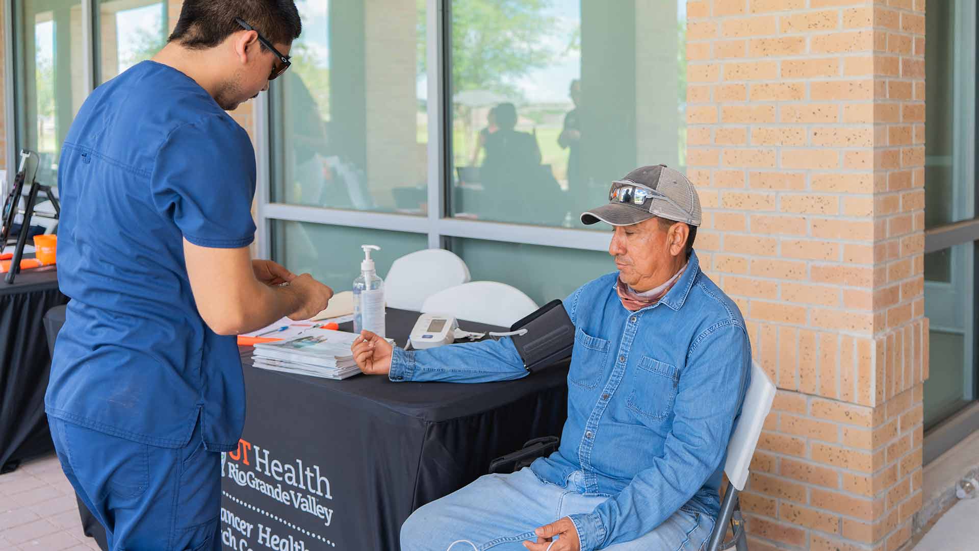 Healthcare professional checks a participant's blood pressure during a community health screening.