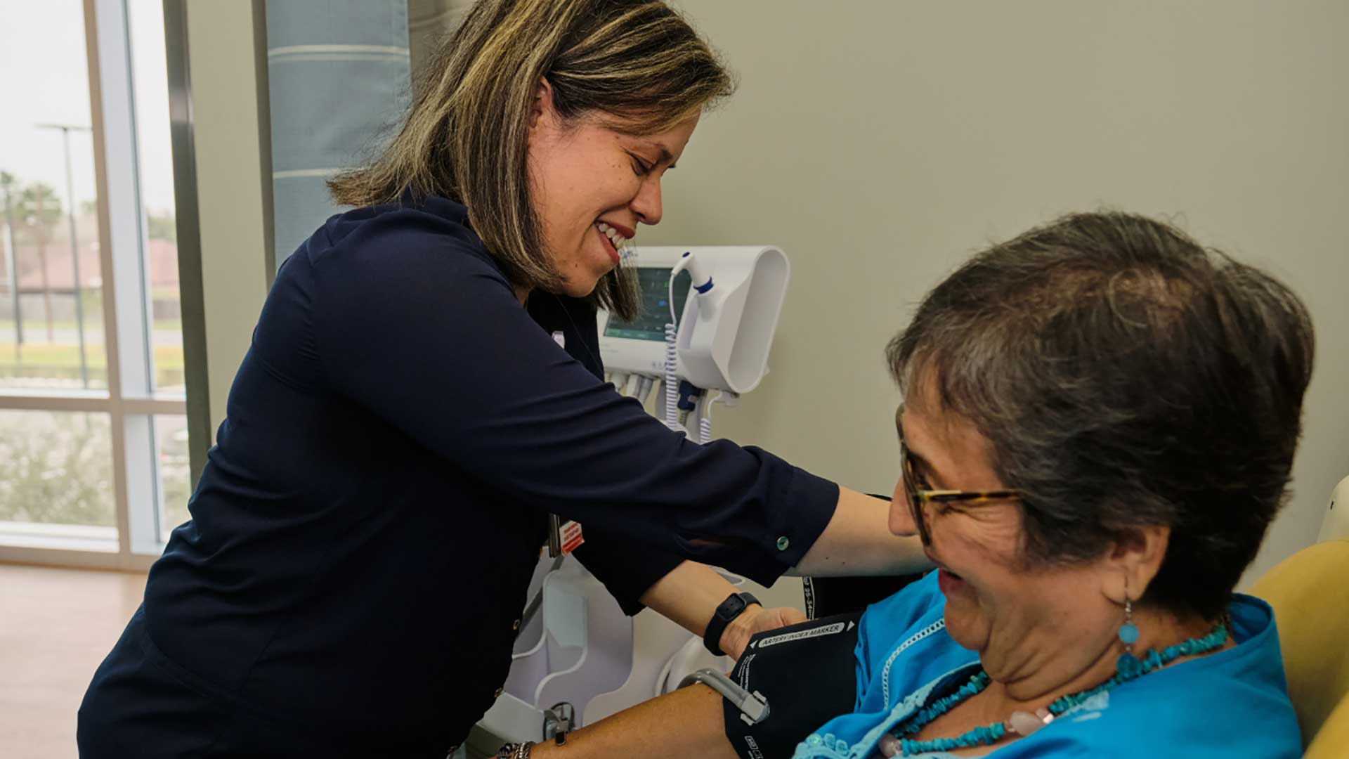 Healthcare professional checks a patient's blood pressure, providing attentive, compassionate care during a routine clinic visit.