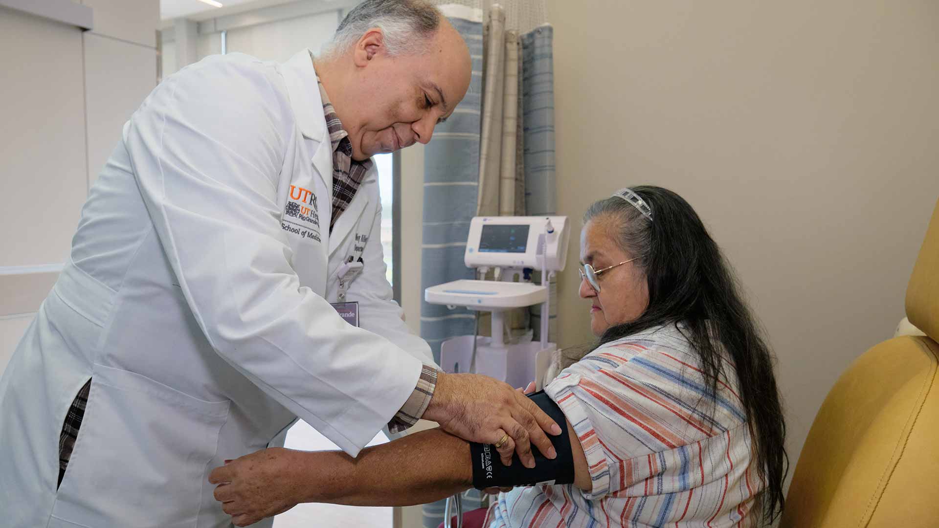 Physician measures an older patient's blood pressure during a clinic visit, providing attentive care and routine health monitoring.