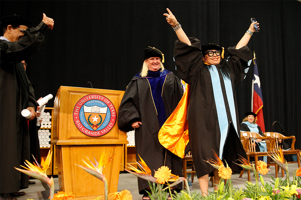 More than 2,000 graduates walked across the stage during the second day of UTRGV’s Spring 2018 Commencement ceremonies, Saturday, May 12, at the McAllen Convention Center. Here, Dr. Maria Edith ‘E.T.’ Treviño, EdD, of Weslaco, celebrates conferral of her doctoral degree in Curriculum and Instruction with specialization in bilingual studies, with a V’s up followed by a quick victory dance onstage. Cheering her on from the audience – ‘That’s my mom!’ – was her daughter, Alexia Treviño, who was graduating during the same ceremony with a Bachelor of Science degree in Nursing. Between Friday’s ceremony in Brownsville, which included more than 700 graduates, and Saturday’s three ceremonies, UTRGV graduated more than 3,100 students this weekend. Since UTRGV opened in 2015, the university has awarded more than 12,800 degrees. (UTRGV Photo by Paul Chouy)