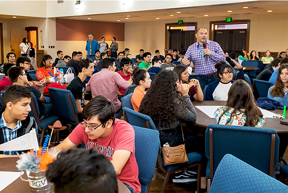 More than 150 Harlingen Early College High School (HECHS) sophomores and juniors visited The University of Texas Rio Grande Valley on May 9 for an orientation and onboarding session prior to starting their college courses next semester. The event was held at the PlainsCapital Bank El Gran Salón on the UTRGV Brownsville Campus. Here, Dr. José Saldivar (standing, with microphone), a UTRGV Lecturer III with the UTRGV University College, explains the difference between active and passive learning, as a way to prepare the Harlingen students for learning and thriving in a university setting. (UTRGV Photo by David Pike)