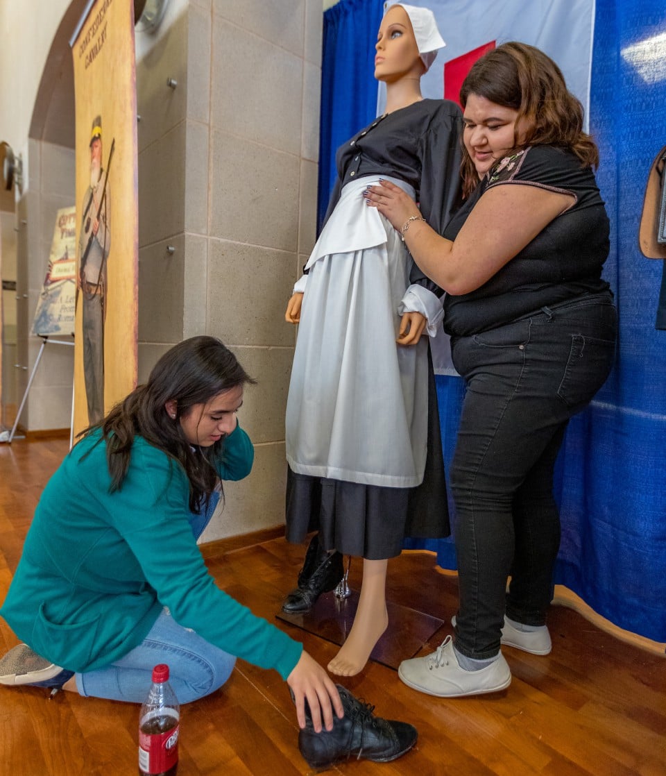 UTRGV students work together to dress exhibit mannequins in recreated historical clothing.