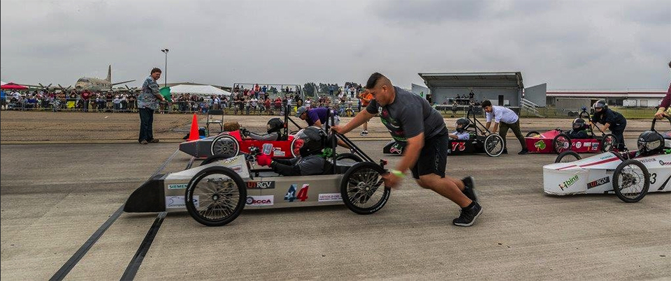 Jim Tipton, president of Tipton Auto Group, a sponsor of the event, waves the flag to start the electric car competition race in 2018. UTRGV was the first to host this competition in Texas. (UTRGV Archive Photo by David Pike)