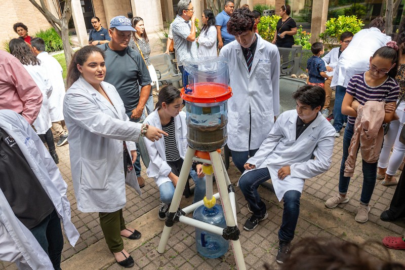 Students demonstrating life-sustaining biofilters for clean water.