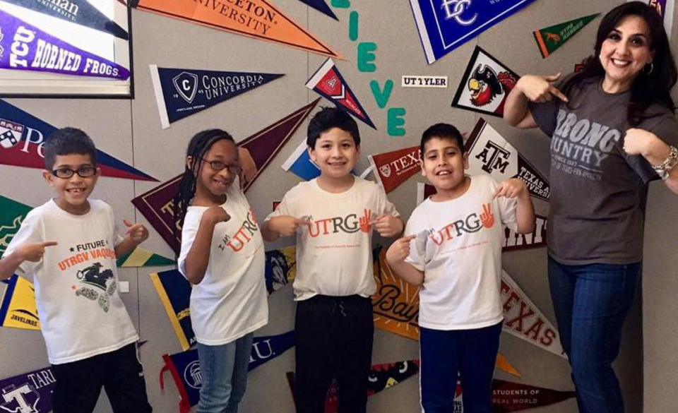 When UTRGV legacy alumna Margaret Medina-Olivarez, a McAllen native, asked universities around the country to send her their T-shirts so she could have a picture of her elementary school students wearing them, her request drew national attention. Olivarez has been a third-grade bilingual teacher at Pflugerville Independent School District’s Copperfield Elementary School for more than 10 years, after earning a bachelor’s degree in Interdisciplinary Studies with a concentration in education from UT Pan American. She is shown here with some of her students wearing the T-shirts garnered during her campaign to bring them awareness of higher education. (Courtesy Photo)