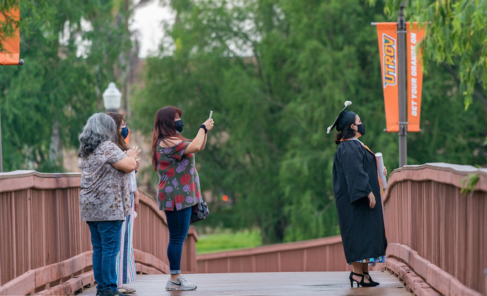 A UTRGV graduate and her family take a moment to commemorate the day with a photo on the popular Brownsville Campus bridge on Thursday. (UTRGV Photo by David Pike)