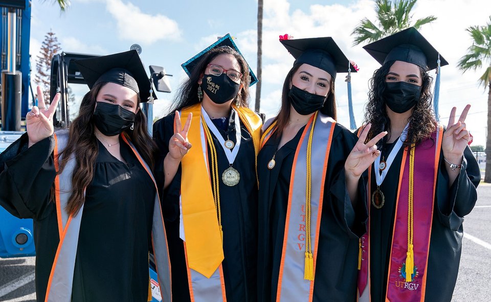 UTRGV graduates showing the V's Up! hand sign