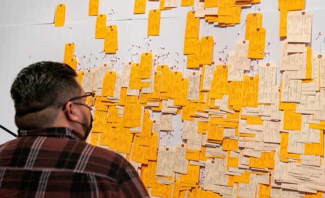 A visitor to the Rusteberg Gallery, on Nov. 1, studies the more than 3,200 handwritten toe tags representing immigrants who have lost their lives crossing the Sonoran Desert of Arizona in the Hostile Terrain 94 installation on display at UTRGV. (UTRGV Photo by David Pike)