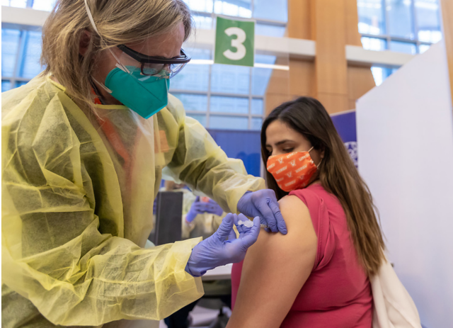 Dr. Linda Nelson gives shot to Dr. Michelle Lopez