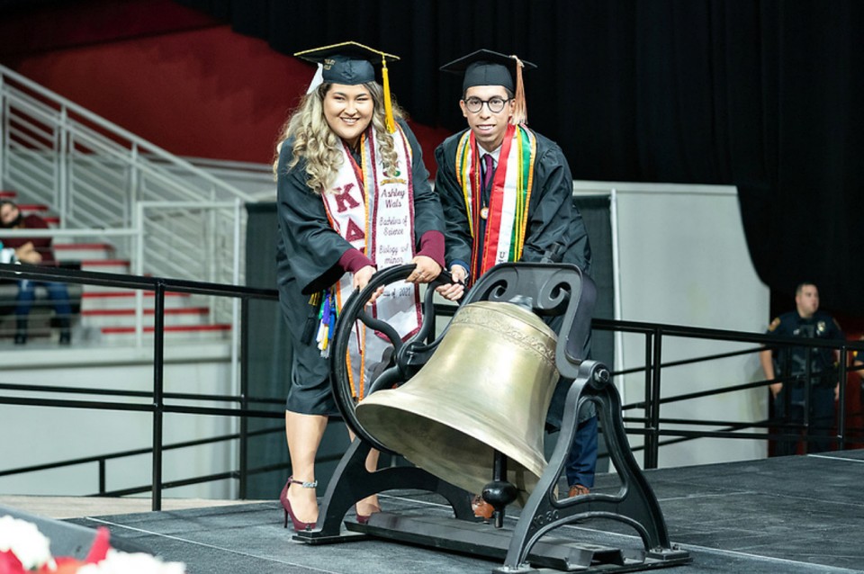UTRGV graduates ring the bell at the end of the ceremony on Saturday morning to signify the end of the special event. The bell has become a symbol for UTRGV as one of the universities traditions demonstrating student pride to all in attendance. (UTRGV Photo by Paul Chouy)