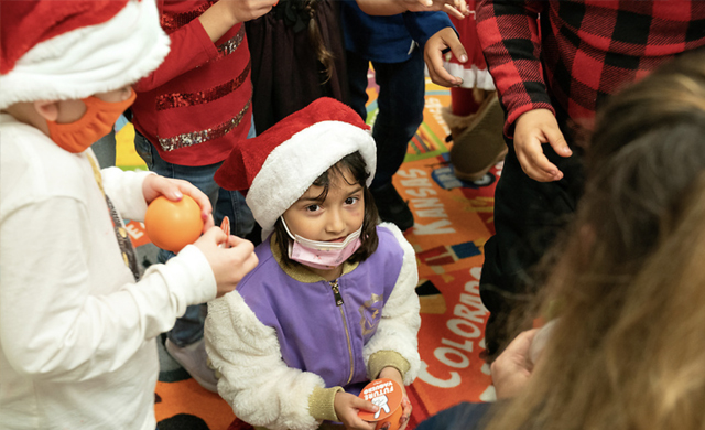 Roosevelt Elementary students in McAllen receive gifts – UTRGV pencils, stress balls and stickers – from Lisa Gonzales, a UTRGV college administrator, as part of the literacy promotion event organized by the UTRGV Office of Community Engagement and UTRGV Staff Senate on Dec. 14. (UTRGV Photo by Paul Chouy)