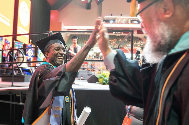 Graduate and professor giving a high five