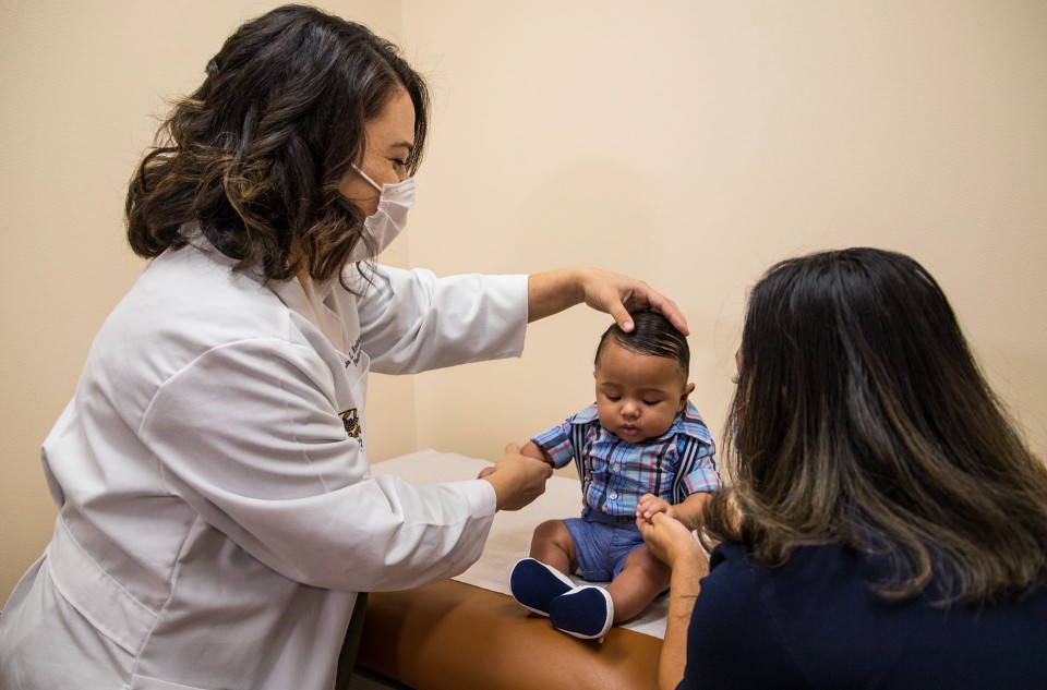 Pediatric doctor examining a child with their parent