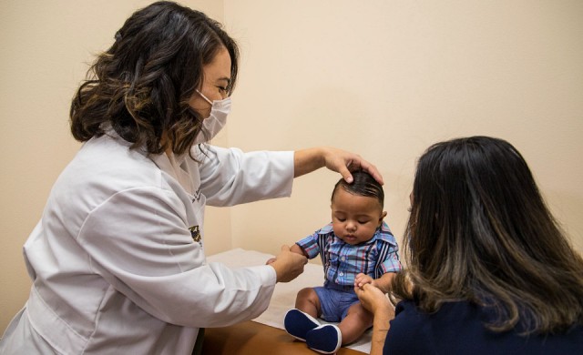 Pediatric doctor examining a child with their parent
