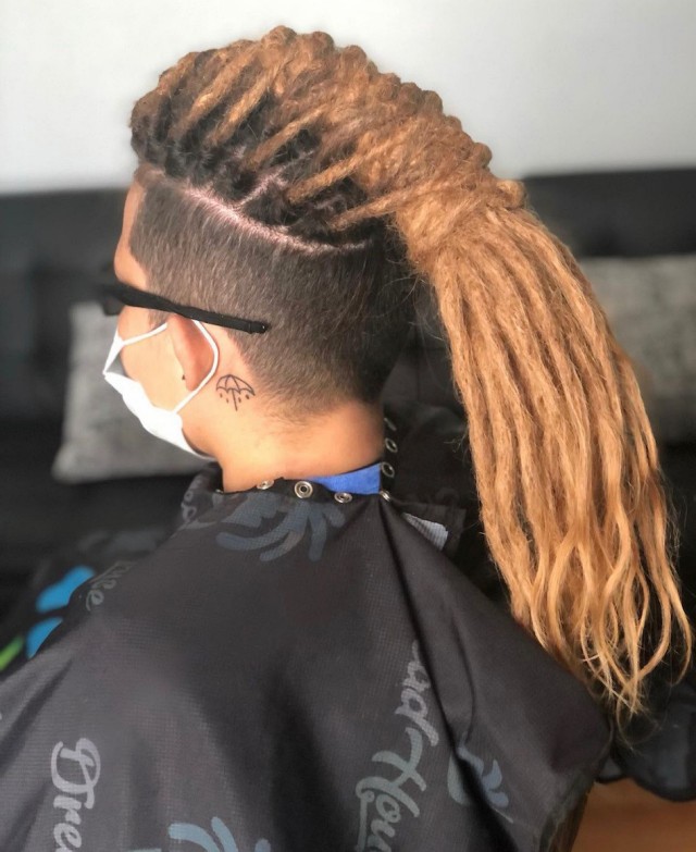 Person with dreadlocks in a salon chair.