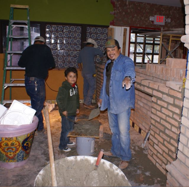 Limon and his son working alongside his team during a construction project.