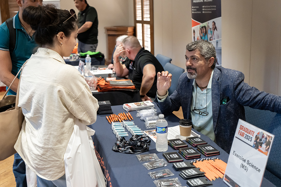 UTRGV Spring 2026 Grad Fair promotional graphic with the text “Your Passport to Something Bigger Begins at the UTRGV Grad Fair!” and a photo-style image of a smiling student making a peace sign.