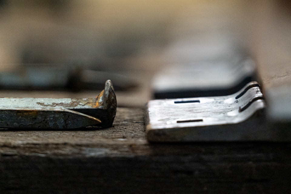 Close up of a rail spike and a rail tie plate on a wooden beam 