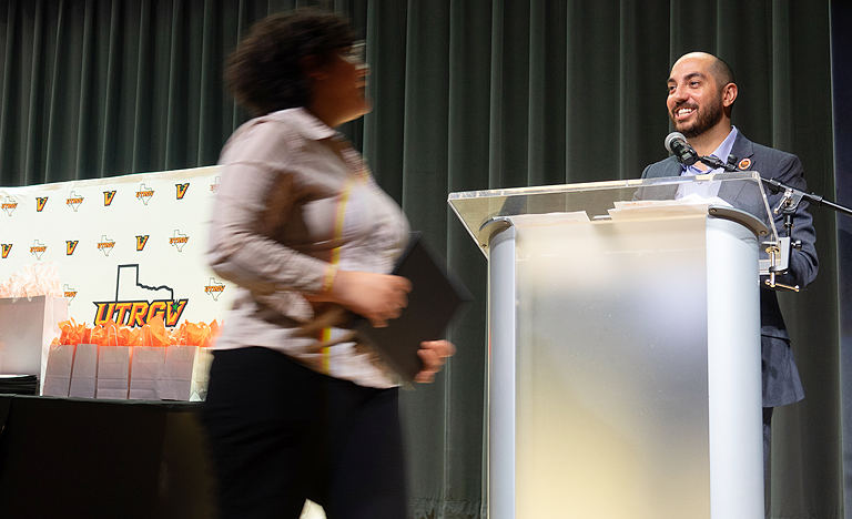 A man standing behind a podium on stage at a ceremony ...