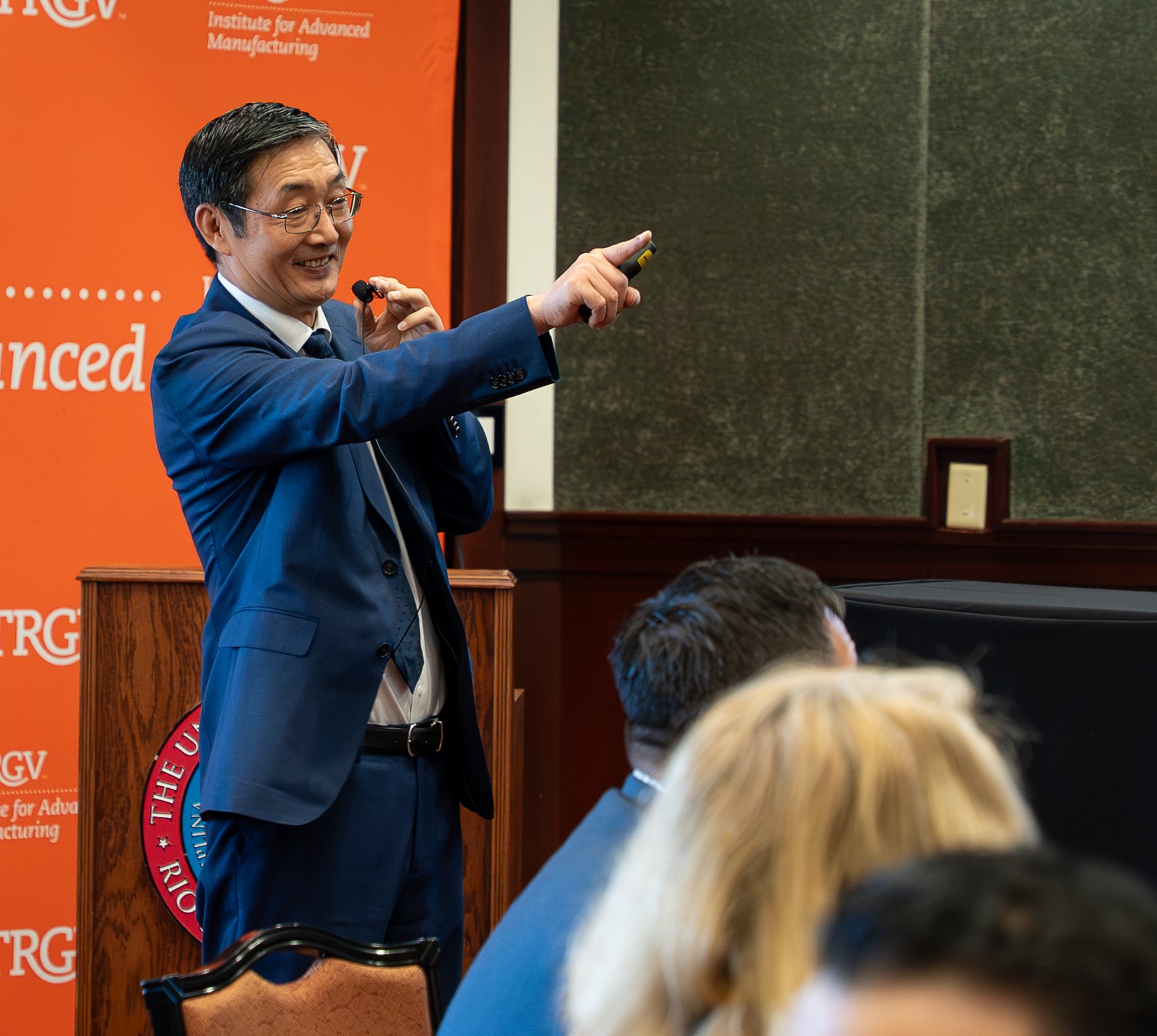 Professor dressed in suit speaking to a crowd