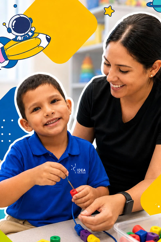 An elementary-aged male student smiles while a female teacher looks on. Toys and classroom in background with shapes.