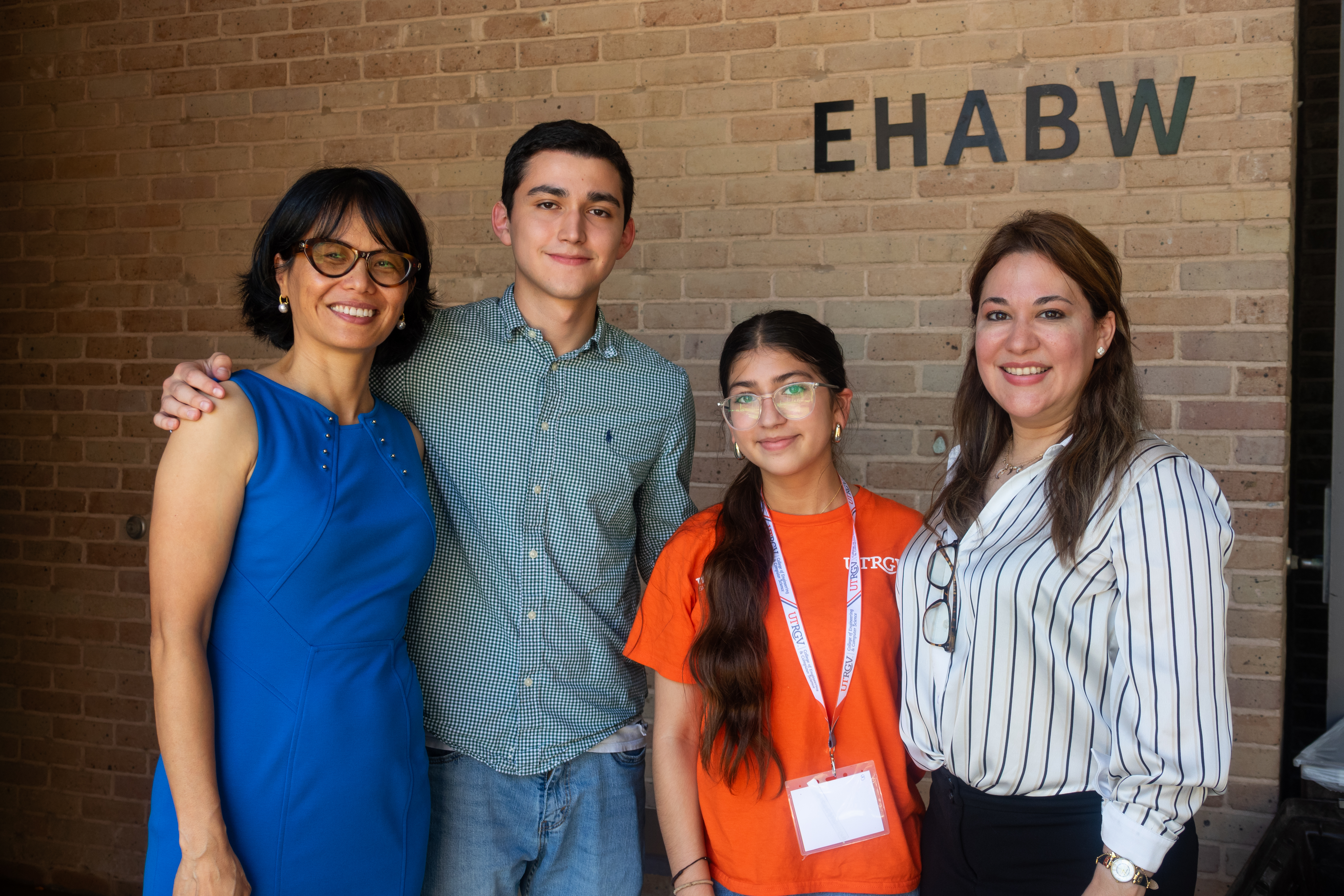 Four people standing together outside of a building 