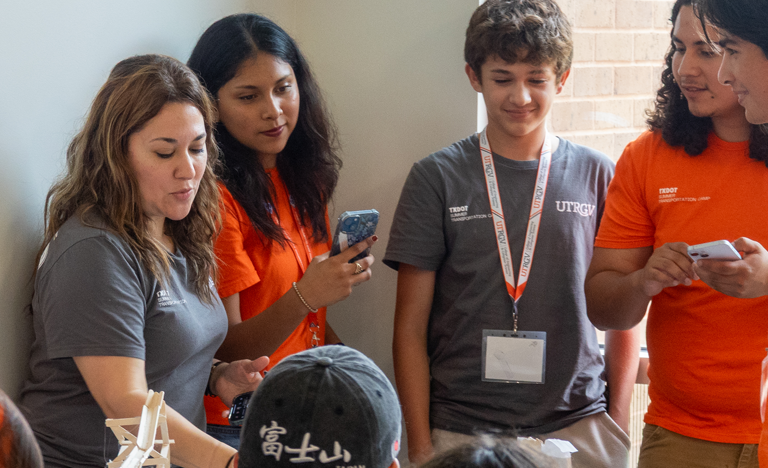 Participants and instructors discuss a project during a ...